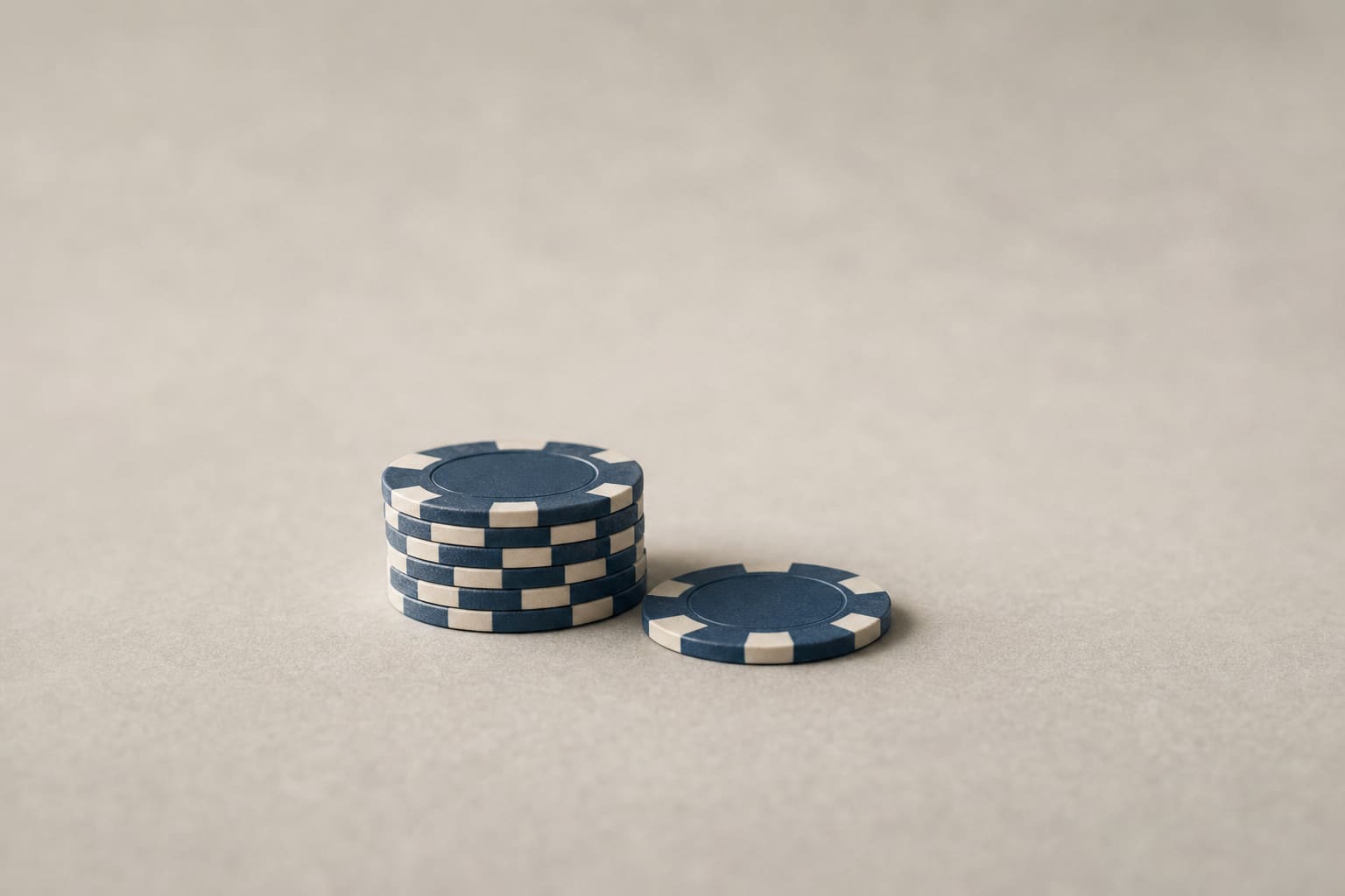 A single modest stack of casino chips with one chip resting beside it
