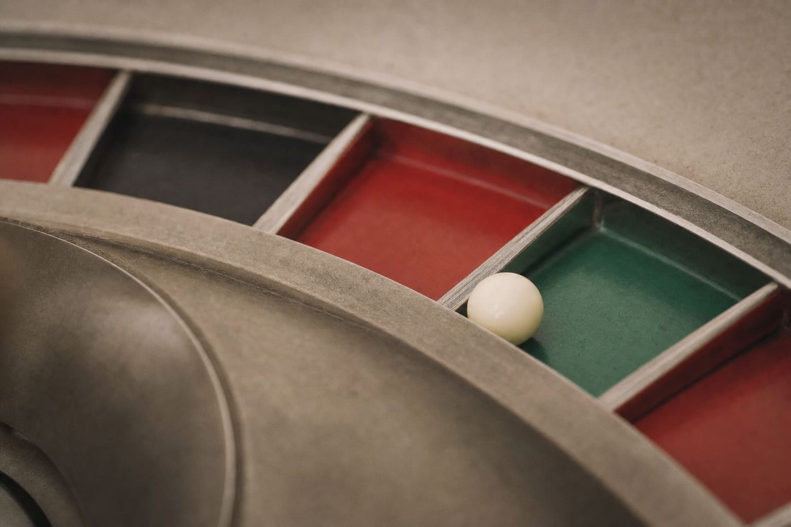 Close-up of the green single-zero pocket of a roulette wheel with the ivory ball resting in it